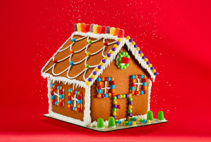 Decorated gingerbread house on red background
