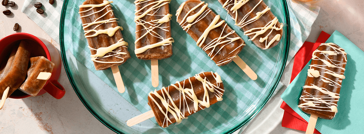 Overhead shot of espresso martini popsicles drizzled with white chocolate
