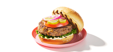 Bacon & Cheddar burger topped with lettuce, tomato, and pickles on a bun.