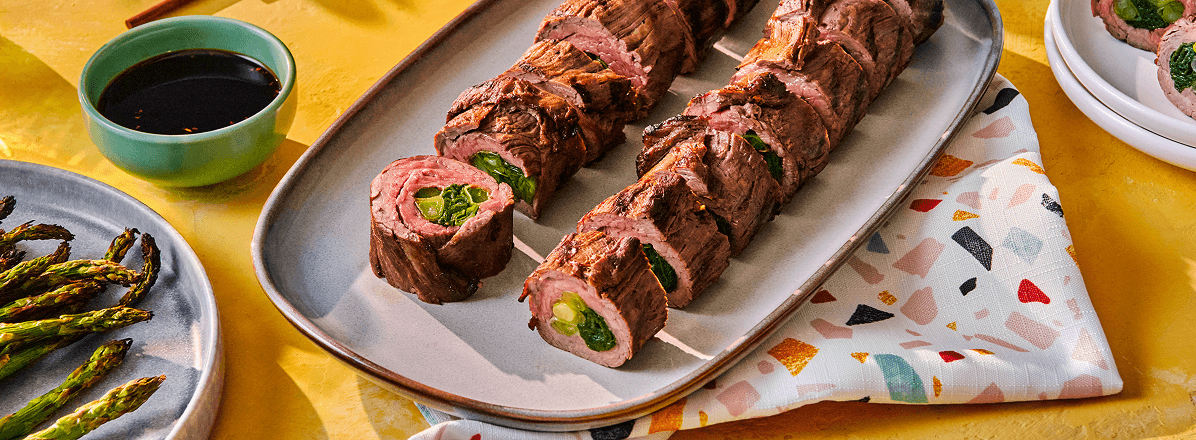 Shot of beef negimaki stuffed with green onion, and sliced on a plate