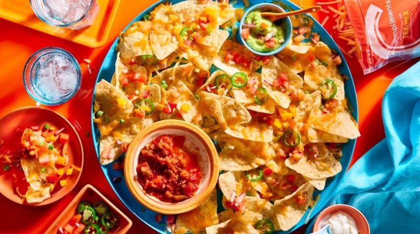 /content/dam/empire/sobeys/assets/articles/compliments/orange-surface-with-a-platter-of-nachos-salsa-and-glasses-of-sparkling-water.jpg
