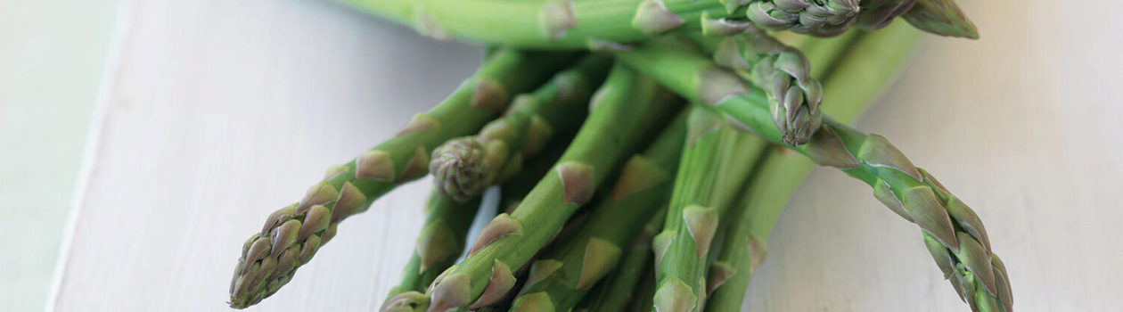 Close up of a bunch of fresh asparagus on a light counter top