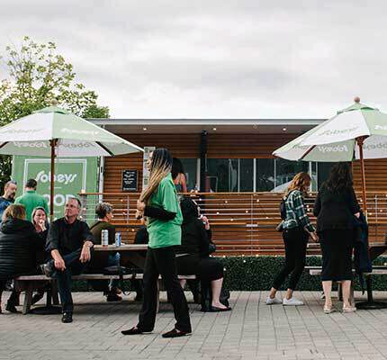 people sitting and standing around tables in front of the Sobeys food truck