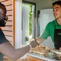 Sobeys food truck employee handing pulled pork slider to customer