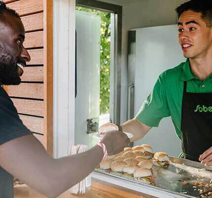 Sobeys food truck employee handing pulled pork slider to customer