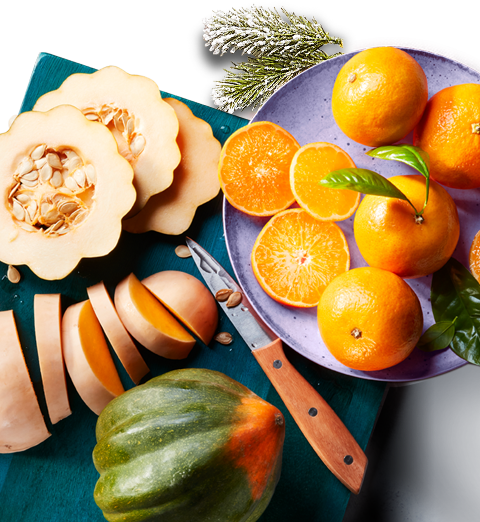 Sliced squash and citrus fruit on a board.