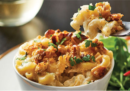 White bowl of mac and blue cheese with green side salad.