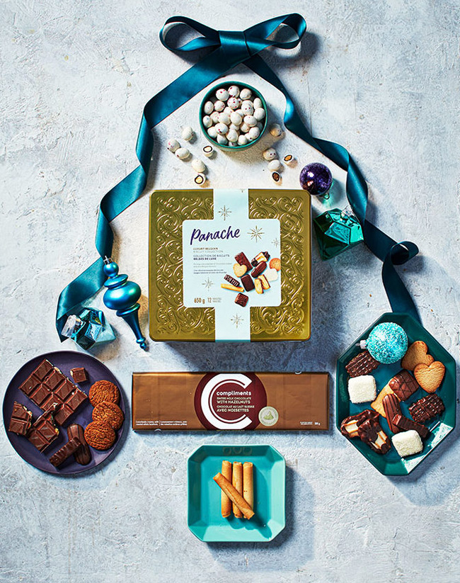Luxury Belgian biscuit collection, chocolate bar and chocolate-peppermint almonds on a marble surface with blue ribbon