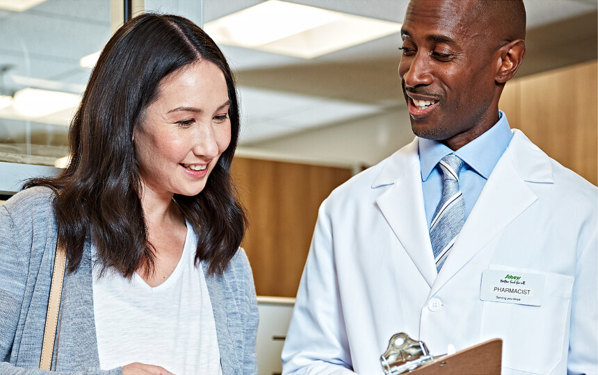 Pharmacist and customer reviewing notes