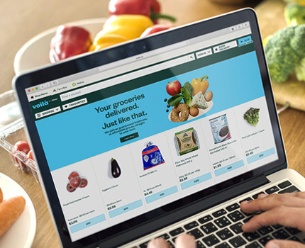 A customer orders their groceries for at-home delivery with the Voila website on their laptop at home.