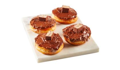 donuts_coffee_crisp Four donuts spread and filled with Coffee Crisp chunks and spread, presented on square white marble surface.