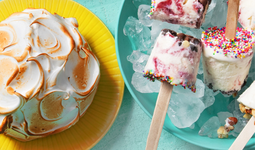 Ice-cream-desserts An assortment of six ice cream desserts including an ice cream sandwich cake with a chocolate drizzle, a Baked Alaska, and decorated cones filled with seasonal ice cream flavours.
