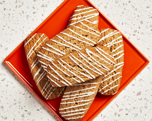 Six rectangular-shaped root beer cookies sitting on a red plate. 