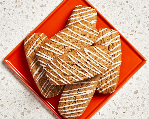 Six rectangular-shaped root beer cookies sitting on a red plate.