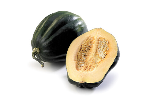 One acorn squash and one cut in half on a white background.
