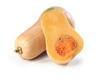 A butternut squash cut in half laying next to a whole one on a white counter. 