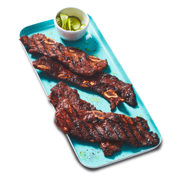 A blue platter of grilled short ribs.