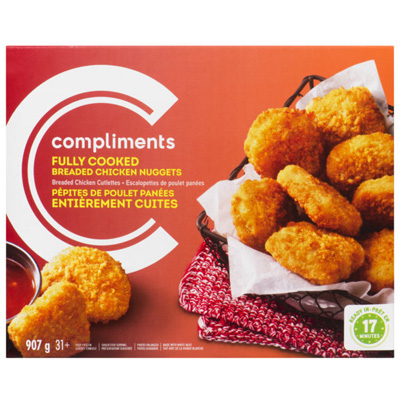 An orange cardboard box of Compliments Fully Cooked Breaded Chicken Nuggets, featuring cooked chicken nuggets in a basket next to a dipping sauce.