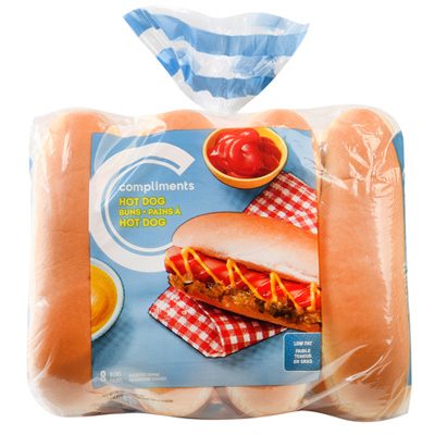 A clear plastic Compliments Hot Dog Buns bag with a blue label showing a fully dressed hot dog on a red-and-white napkin.