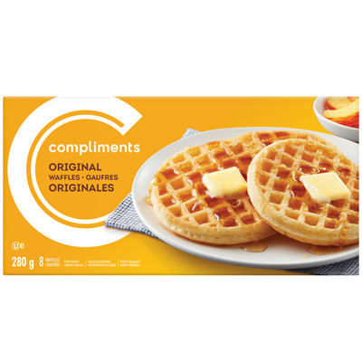 A yellow cardboard Compliments Original Waffles box, depicting two toasted waffles dressed with maple syrup and butter on a white plate.