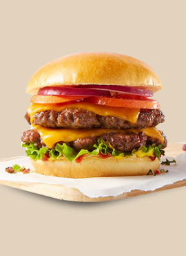 Double-patty smash burger dressed with condiments, tomato slices, onion, and lettuce.
