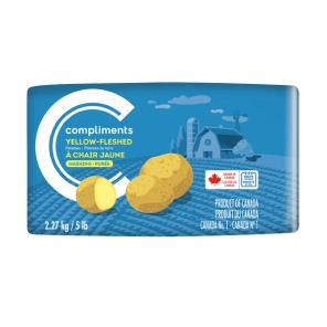Blue paper bag package of Compliments yellow-fleshed mashing potatoes with a barn illustration.