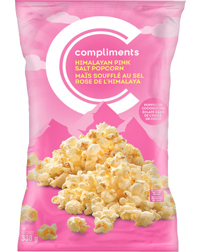 Pink bag of Compliments Himalayan Pink Salt Popcorn mounded over an illustration of the Himalayan mountain range on package.