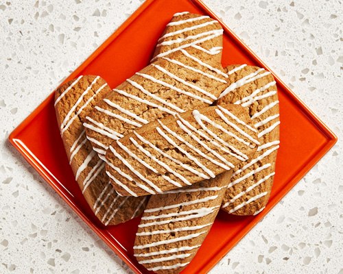 Six rectangular-shaped root beer cookies sitting on a red plate.