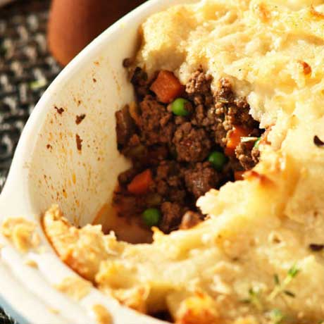 White baking dish filled with a big shepherd’s pie topped with mashed potato.