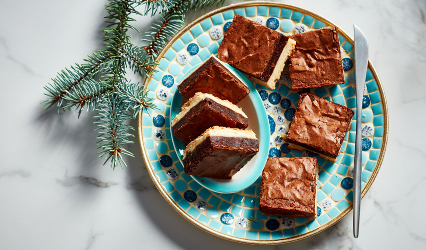 Brownie-Shortbread-Bars A blue mosaic plate of brownie shortbread bars with a knife sitting on the plate.