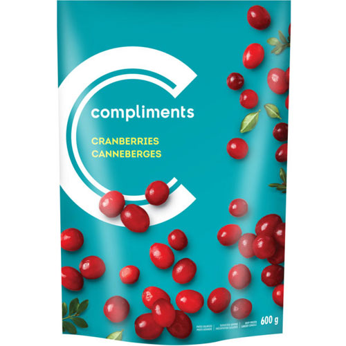 Teal bag of cranberries with cranberries scattered on it, or cranberries in a bag with a blue label with illustration of a barn