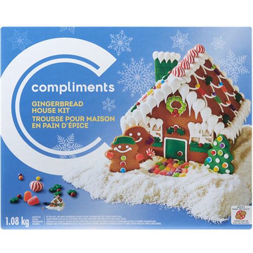 Blue box with a photo of a gingerbread house decorated with candy and icing with two decorated ginger-people in the front