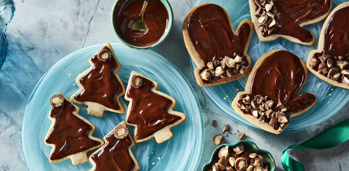  Gingerbread spiced sugar cookies topped with melted chocolate and decorated with pieces of Compliments Gingerbread Flavoured Milk Chocolate Covered Almonds.