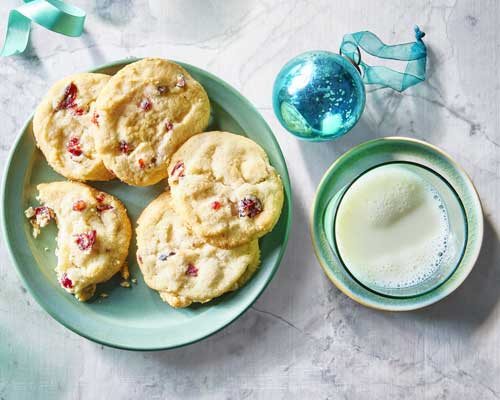 Green plate topped with Bakery Department made cranberry white chocolate shortbread cookies.