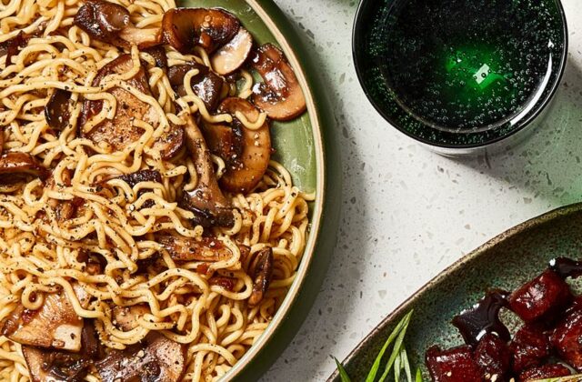 Blue bowl full of ramen noodles with mushrooms.