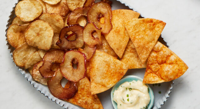 Blue serving platter with three types of chips: apple, tortilla and potato.