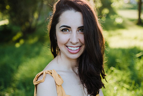 Image of Sarjesa Tea founder, standing outside in yellow dress.