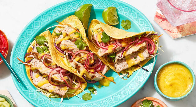 Various grilled mahi mahi tacos packed with pickled onions, spicy mango-jalapeno sauce and an avo-line crema.