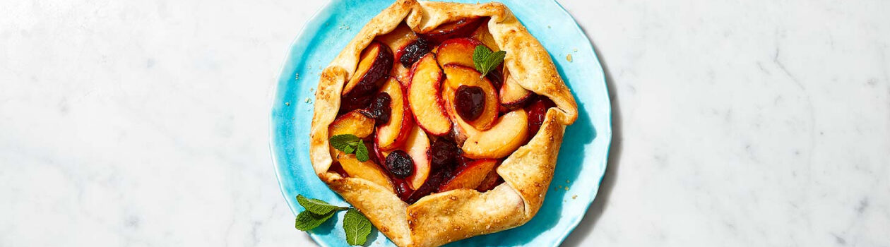 Blue serving platter featuring a baked stone fruit galette.