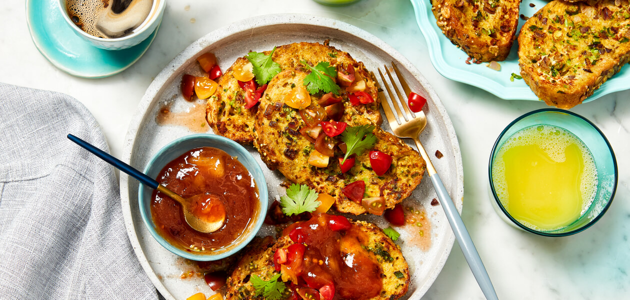 Savoury French toast slices on a beige plate topped with fresh cherry tomato salsa.