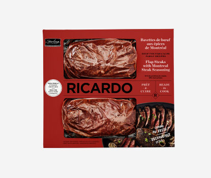 Red cardboard packaging with two portions of cryovac-wrapped Ricardo Flap Steaks with Montreal Steak Seasoning peering through the red package windows.