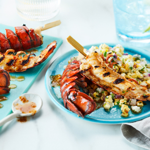 Jerk spiced lobster tail on an aquamarine blue plate next to a charred corn salad
