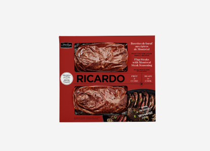 Red cardboard packaging with two portions of cryovac-wrapped Ricardo Flap Steaks with Montreal Steak Seasoning peering through the red package windows.