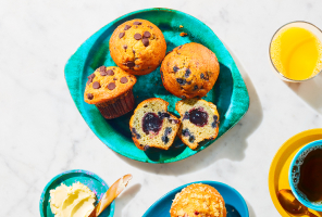 Strawberry, blueberry and chocolate chip muffins on a green platter.