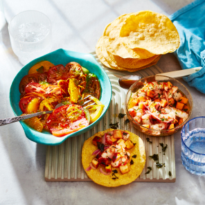 Green plate topped with shrimp and peach ceviche over a tortilla shell.