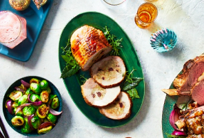 stuffed turkey breast medallions on green serving dish with utensils and Brussel sprouts.