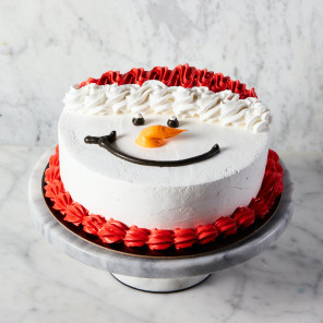 Festive confetti cake decorated as snowman with santa hat