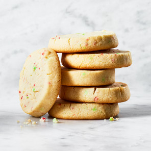 Six peppermint shortbread cookies stacked against a marble background