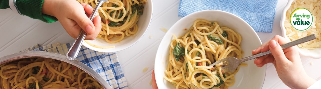 Two white bowls of Pasta with Sundried Tomatoes and Spinach