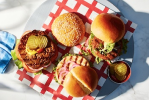 Plate of three varieties of cooked and ready to eat Compliments frozen burgers